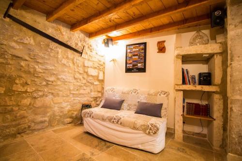 - une chambre avec un canapé au mur en pierre dans l'établissement Maison tout confort, climatisée, dans le Centre Historique avec parking privé., à Saint-Rémy-de-Provence