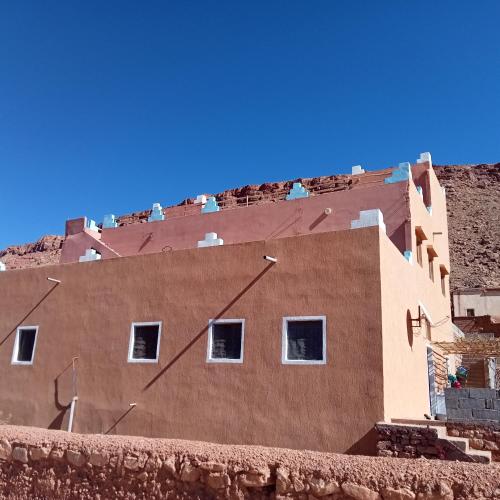 a brown building with white windows on top of it at Dar Brahim Resto Beds in Ouarzazate