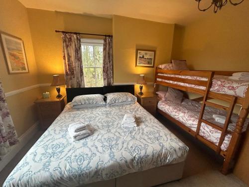 1 dormitorio con 2 literas y ventana en The Postgate Inn en Egton