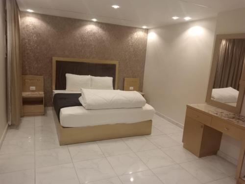 een slaapkamer met een groot bed en een spiegel bij لاصحاب التميز شقة راقية في المهندسين بالقرب من جامعة الدول والنيل in Caïro