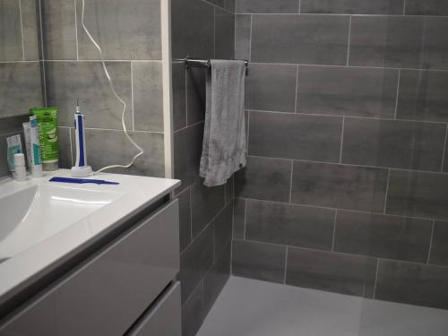 a bathroom with a sink and a tiled wall at Charmant 2 pièces cabine au centre de Font-Romeu, parking inclus - FR-1-580-96 in Font Romeu Odeillo Via