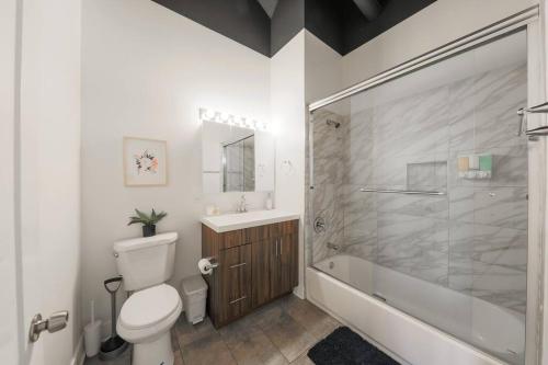 een badkamer met een toilet, een wastafel en een douche bij McCormick 2Br/2Ba family unit for up to 6 guests with Optional Parking & Gym access in Chicago