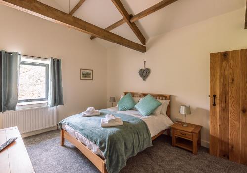 a bedroom with a bed and a window at Union Farm Cottage in Reeth