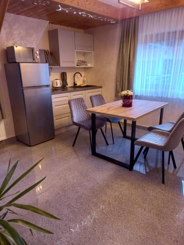 cocina con mesa, sillas y nevera en Apartament 6 osobowy Pasternik en Ciche Małe
