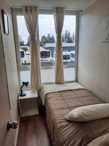 um quarto com 2 camas e uma janela em Depto con Estacionamiento em Puerto Montt