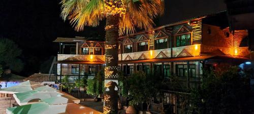 un gran edificio con una palmera delante en Manastırhan Otel Kazdağları, en Balıkesir