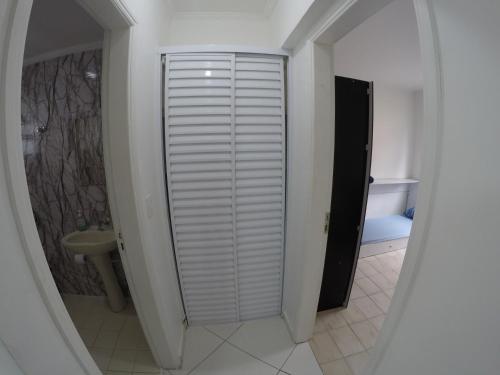 La salle de bains est pourvue d'une douche à l'italienne et d'un lavabo. dans l'établissement A melhor localização da PG. Com ar cond.!, à Praia Grande