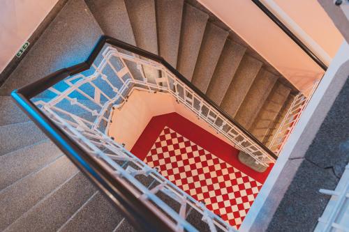 an ascending staircase with a red and white checkered floor at Kavárna a penzion REICHL in Králíky