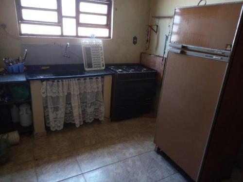 a kitchen with a refrigerator and a stove and a window at Recanto Averomar in Itanhaém
