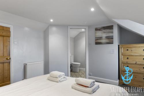 - une chambre avec un lit et 2 serviettes dans l'établissement Coastal View Cottage, à Torquay