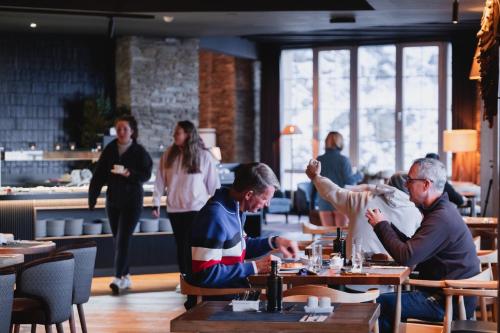 シエラネバダにあるThe Mountains Hotelのレストランのテーブルに座っている人々のグループ