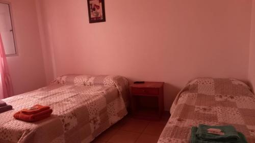 two beds in a small room with red shoes on them at Bella Vista in Gobernador Gregores