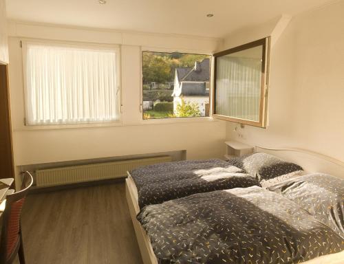a bedroom with a bed and a window at Weinhaus Burg-Schneider in Reil