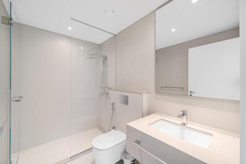 a bathroom with a toilet and a sink and a mirror at 3Bed Private Beach - Belle vie à La Vie Dubai in Dubai
