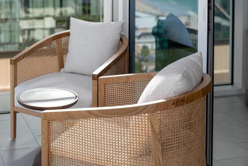 a wicker chair with a pillow and a table at 3Bed Private Beach - Belle vie à La Vie Dubai in Dubai