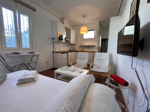 セビリアにあるÁtico La Judería V33のベッドと椅子、キッチンが備わる客室です。