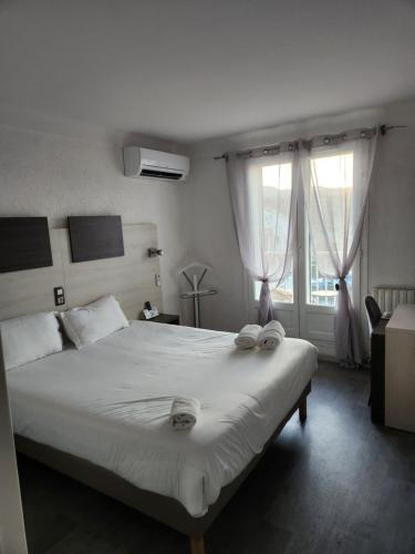 a bedroom with a large bed with two towels on it at Logis Les Charmettes in Argelès-sur-Mer