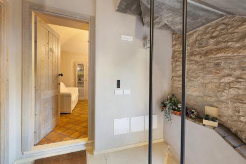 a hallway with a stone wall and a glass door at Casa Virginia - Corbezzolo in Orco Feglino