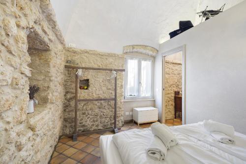 a bedroom with a bed and a stone wall at Casa Virginia - Corbezzolo in Orco Feglino