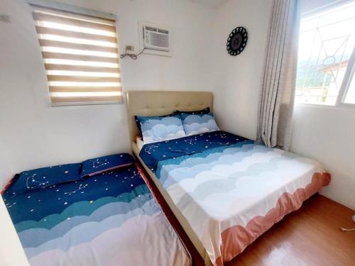 a bedroom with two beds in a room with a window at Cozy Corner at Camella Subic Vista Estates in Subic