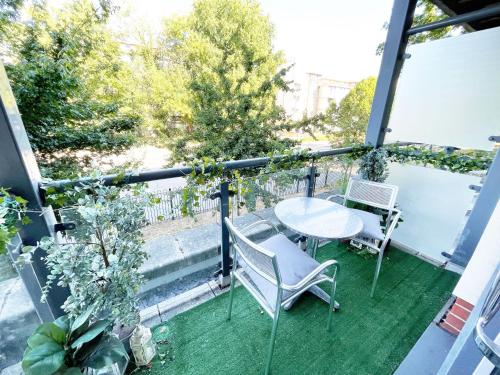 a patio with a table and chairs on a balcony at Travaal.©om - 2 Bed Apartment Farnborough in Farnborough