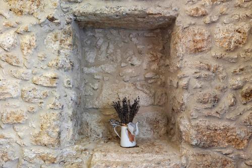 a vase with flowers in it sitting on a stone wall at Casa Virginia - Corbezzolo in Orco Feglino