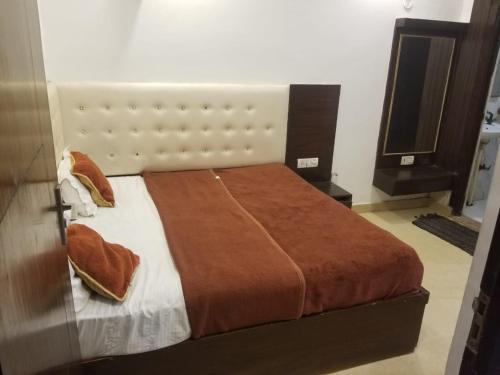 een slaapkamer met een groot bed en een televisie bij evergreen family homesty in Agra