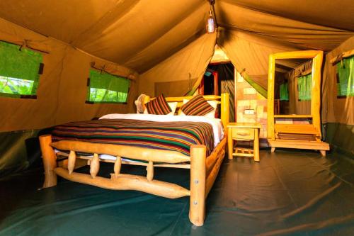 ein Schlafzimmer mit einem Bett in einem Zelt in der Unterkunft Seven Ranges Hotel in Moroto