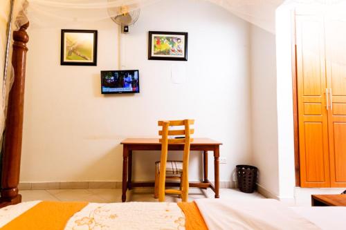 - une chambre avec une table et une chaise à côté d'un lit dans l'établissement Seven Ranges Hotel, à Moroto