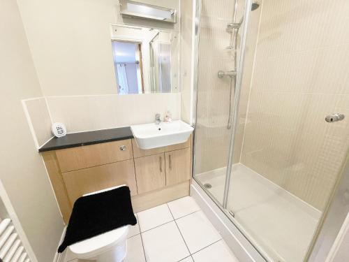 ein Bad mit einer Dusche, einem WC und einem Waschbecken in der Unterkunft Travaal.©om - 2 Bed Apartment Farnborough in Farnborough