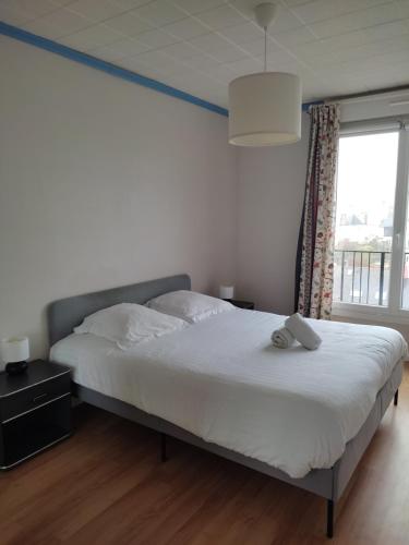 une chambre avec un grand lit et une fenêtre dans l'établissement Appt 2 ch vue mer à 5' de la gare de BREST, à Brest