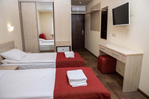 a hotel room with two beds and a mirror at Kohavi Forest Club in Orlovshchina