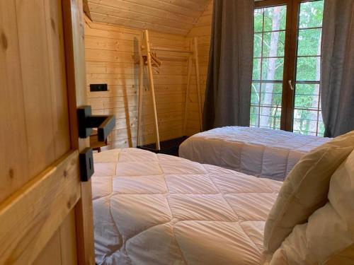 una camera con 2 letti in una baita di tronchi di Apartamenty Leśna Przystań 2 a Węgorzewo