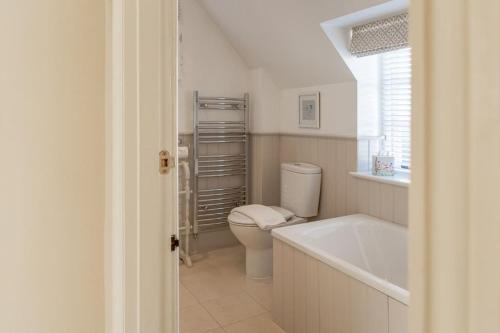 uma casa de banho com um WC e uma banheira em Jasmine Cottage - 2 Bedroom in Heart of Bourton! em Bourton on the Water