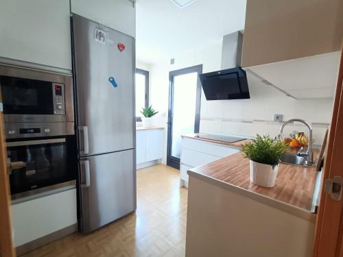 a kitchen with a stainless steel refrigerator and white cabinets at Acogedora habitación privada en Villa Mayka in Granada