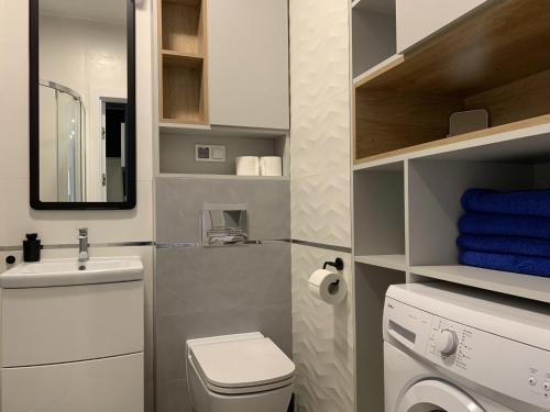 małą łazienkę z toaletą i umywalką w obiekcie Apartamenty Wrzeszcz by Q4Apartments w Gdańsku