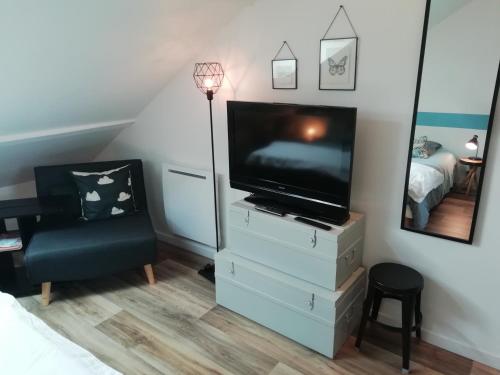 een woonkamer met een tv en een stoel bij Studio au coeur de la vallée de la Loire in Azay-sur-Cher
