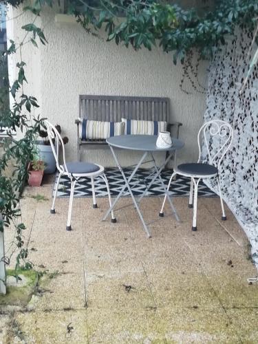 a table and two chairs sitting next to a bench at Studio au coeur de la vallée de la Loire in Azay-sur-Cher