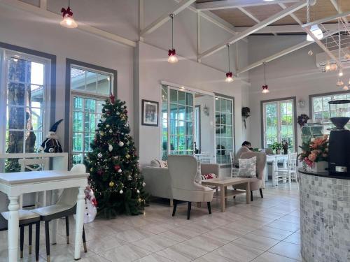 ein Weihnachtsbaum in einem Restaurant mit einem Weihnachtsbaum im Zimmer in der Unterkunft Me and Tree Villa in Kaeng Khoi