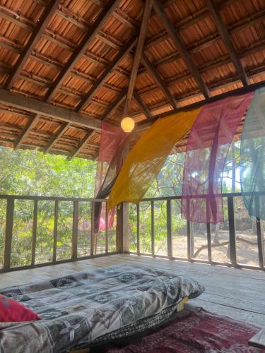 a bed in a tent in a room with windows at The Wild Flower! in Anjuna