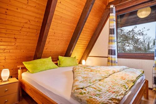 - une chambre avec un lit dans une pièce en bois dans l'établissement Gemütliches Nurdachhaus Bodensee, à Immenstaad am Bodensee