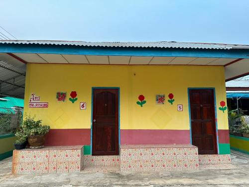 ein farbenfrohes Haus mit drei Türen darauf in der Unterkunft ปาล์ม รีสอร์ท Palm Resort in Non Sang
