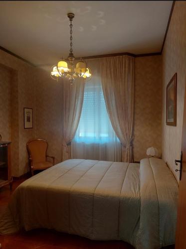 una camera da letto con un letto con un lampadario a braccio e una finestra di Casa Cecè a Canicattì