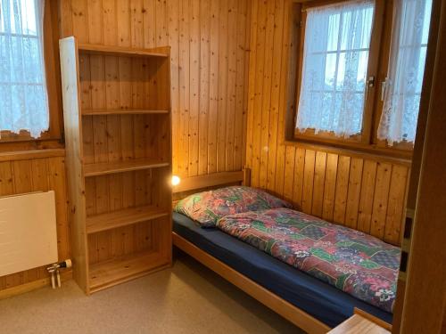 RosswaldにあるChalet Gerberaのベッド2台と窓2つが備わる小さな客室です。