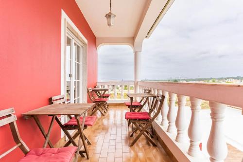 un balcone con tavolo e sedie in legno e un balcone di Moradia Arrifana Ocean View ad Aljezur