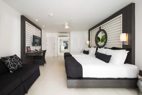 Un dormitorio con una cama grande y un sofá. en S Hotel Montego Bay - Luxury Boutique All-Inclusive Hotel, en Montego Bay