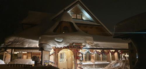 una casa de pan de jengibre con luces de Navidad en ella en Gospoda Harnaś, en Kościelisko