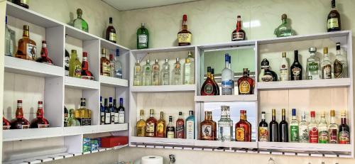 un estante lleno de botellas de alcohol en Cruzeiro Guest House, en São Filipe