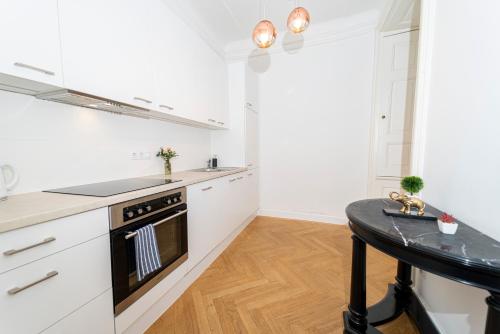 een keuken met witte kasten en een fornuis met oven bij CENTRAL Stephansdom apartment I Netflix I Self Check In in Wenen