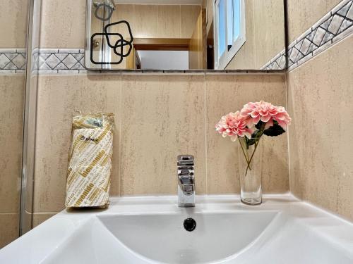 a white sink with a vase of flowers on it at Dunas Home by Gloove in Gran Alacant